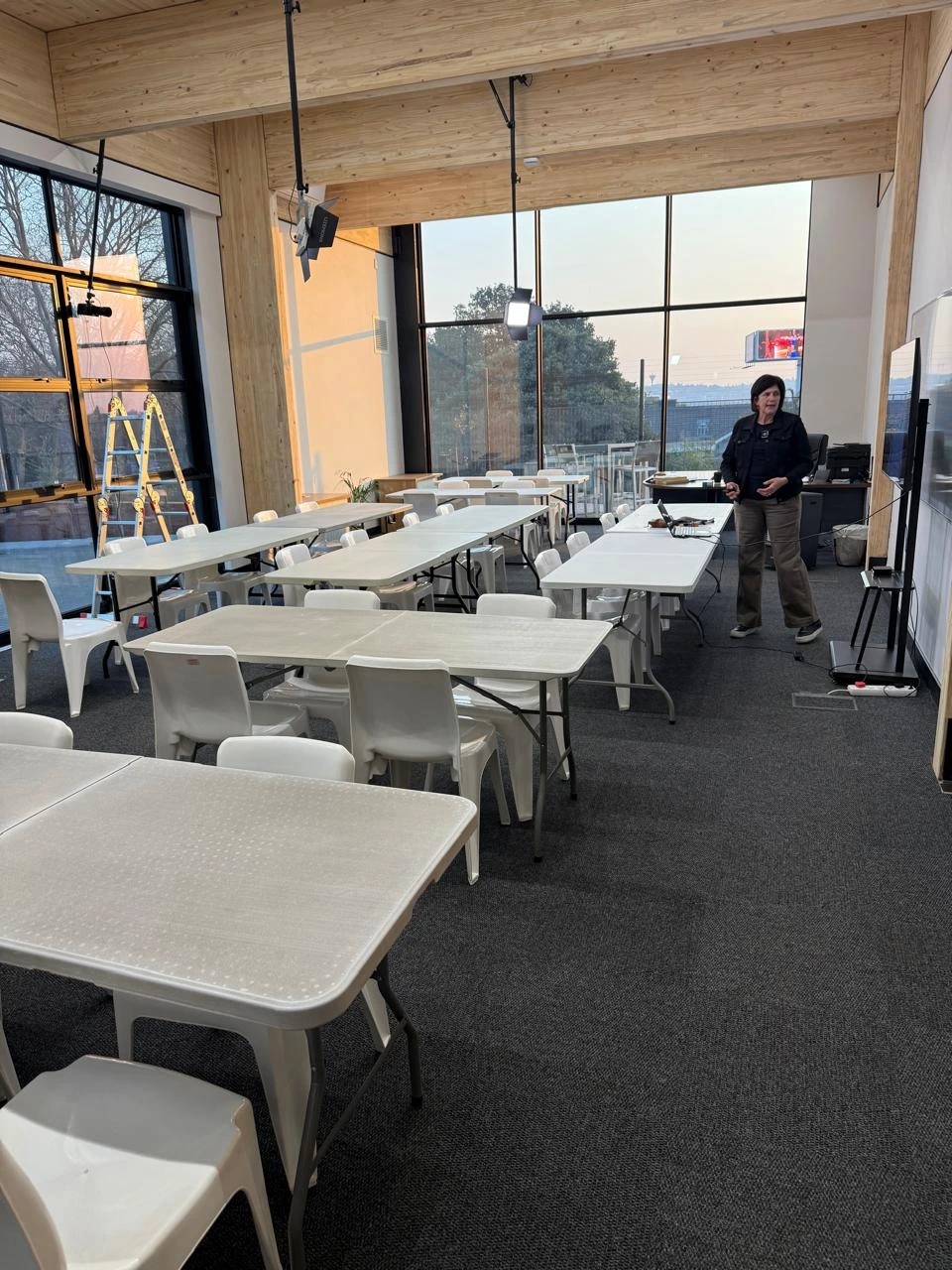 Training room at the Seventh Star venue with trestle tables and chairs arranged in clusters, exposed timber beams overhead and daylight from full-height windows